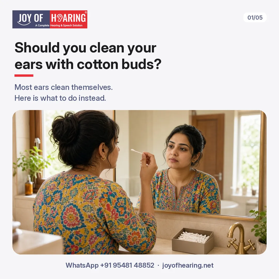 A woman in a colourful kurta stands at her bathroom mirror holding a cotton bud away from her face, with a box of cotton buds on the shelf.